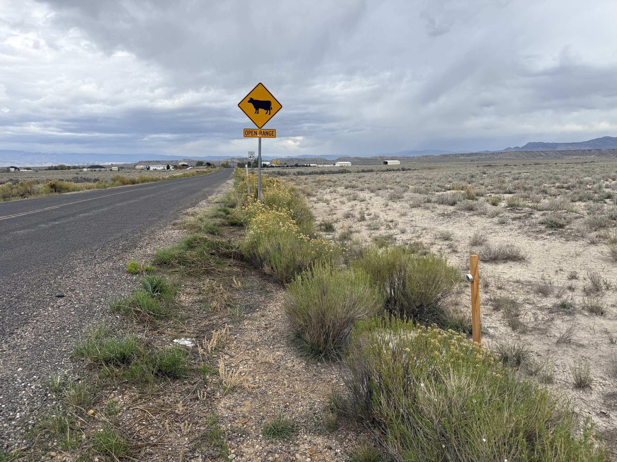 A post marking Valar Atomics' RW 453 lode claim beside the road northeast of Wellington, October 2026. Homes stand in the distance.